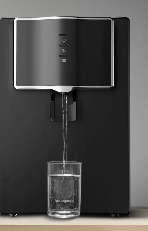Aquaguard Marvel NXT RO purifier dispensing water into a glass on a kitchen counter